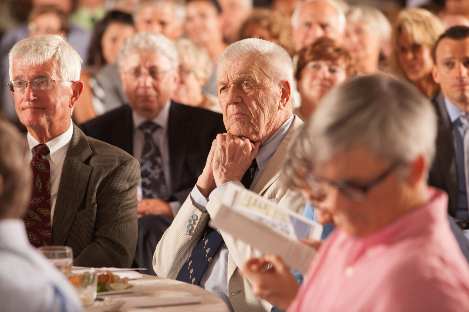 A group of people sitting at tables with papers.