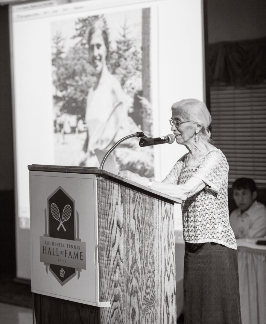 A woman standing at the top of a podium speaking.