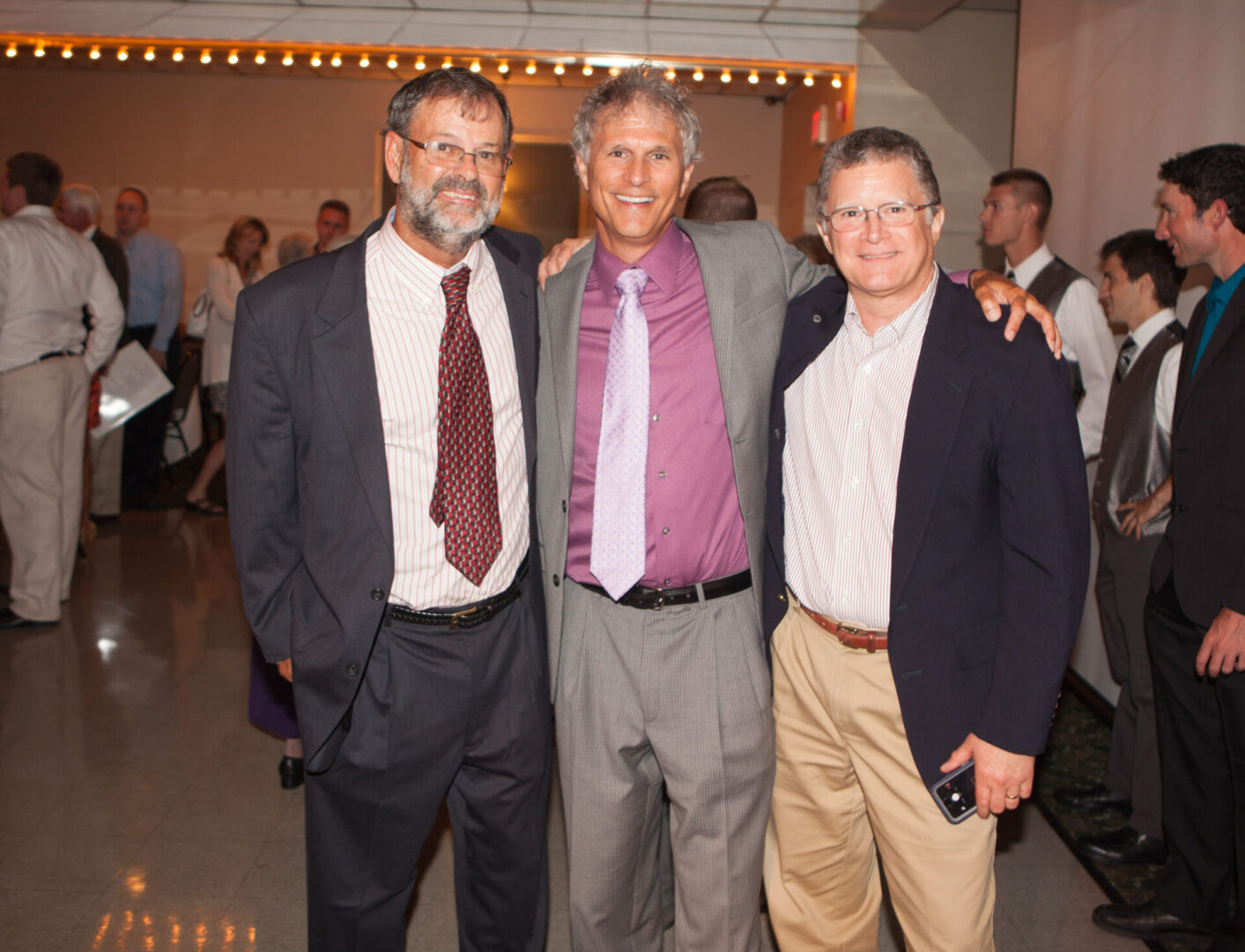 Three men in suits and ties posing for a picture.