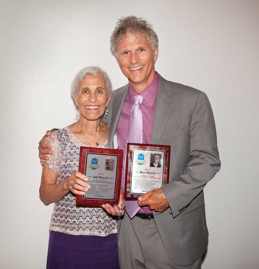 A man and woman holding plaques in front of them.