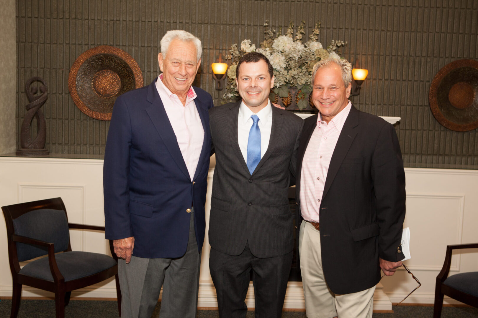 Three men in suits posing for a picture.