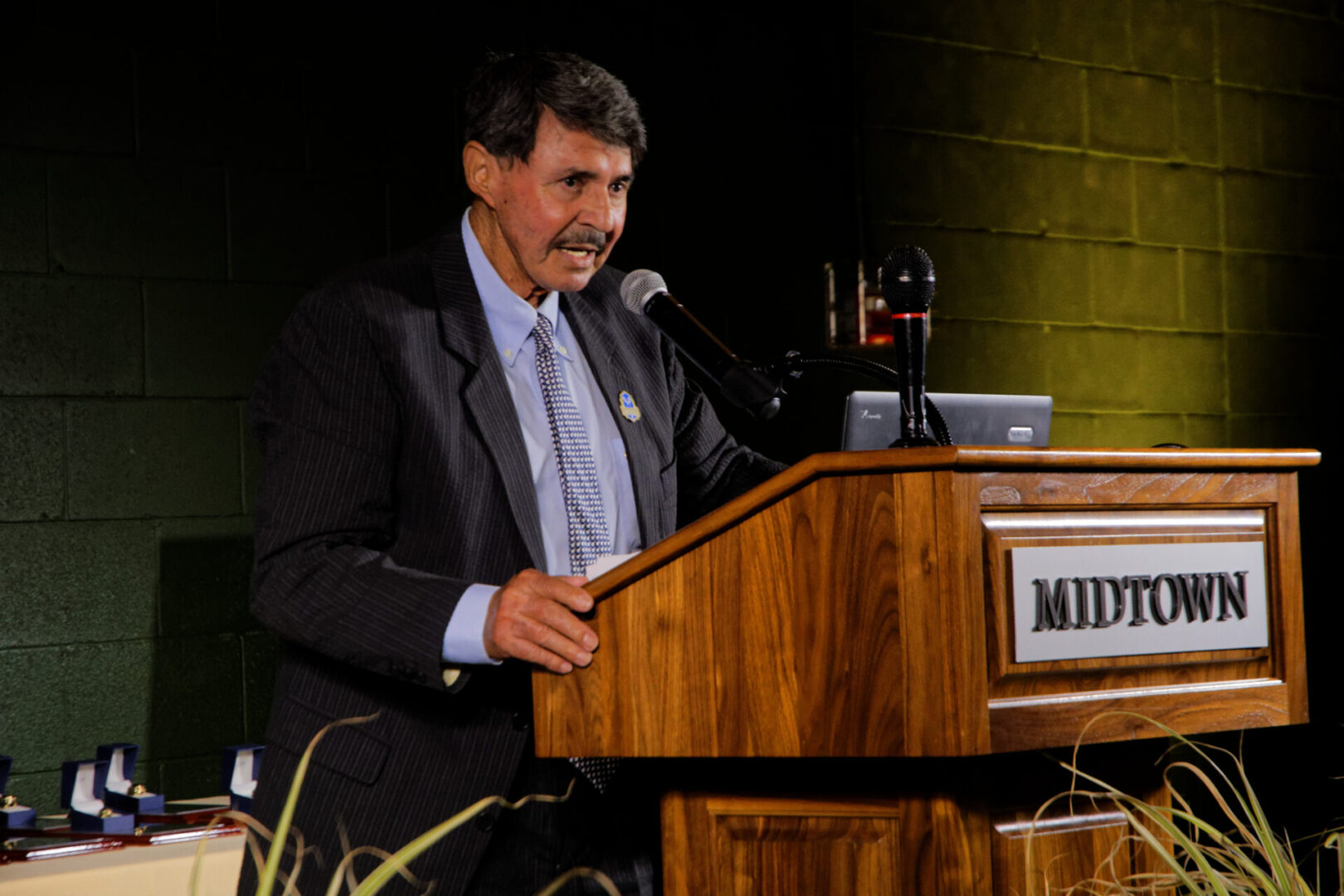 A man in suit and tie at podium speaking.