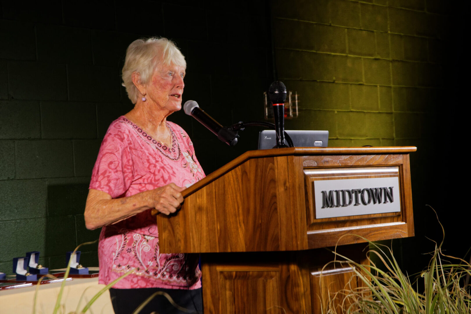 A woman standing at the top of a podium speaking.