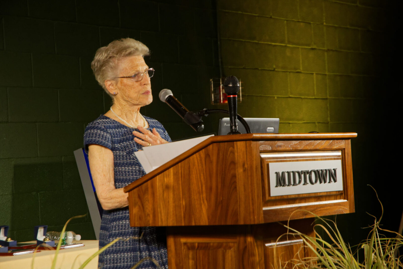 A woman is speaking at a podium in front of a microphone.