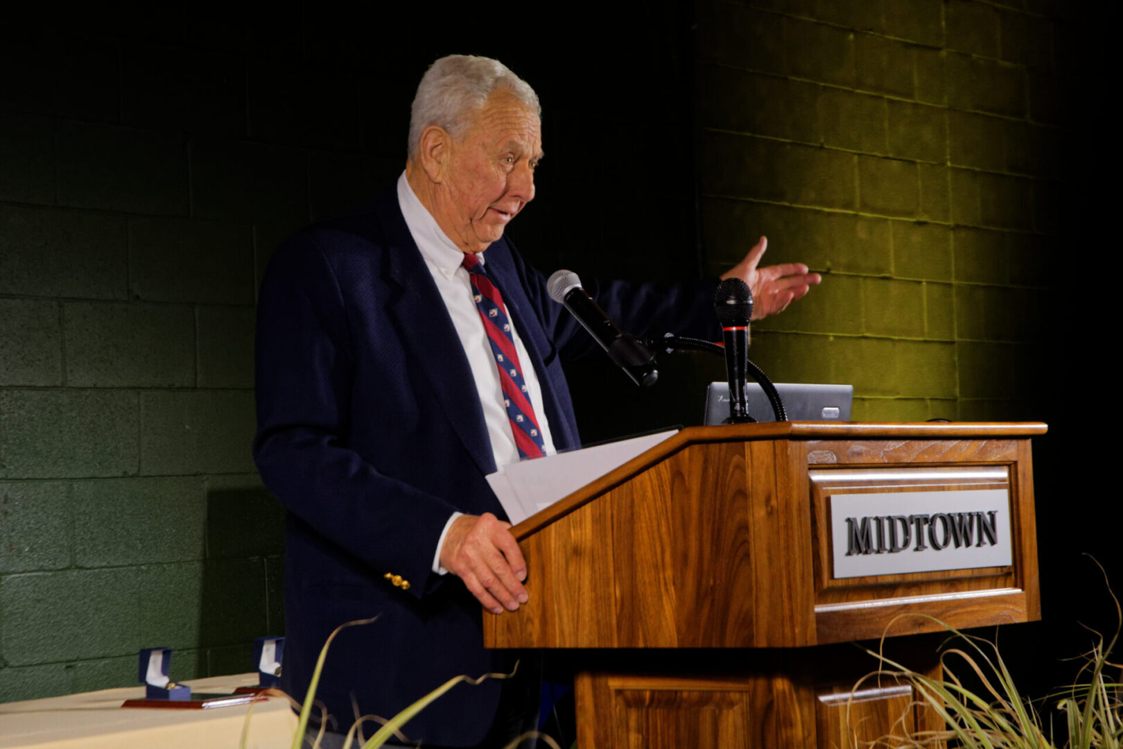 A man in suit and tie at podium speaking.